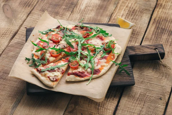 Pizza italiana na tábua de madeira de perto — Fotografia de Stock