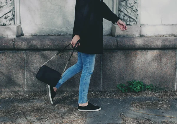 Жінка в чорному пальто, джинси — стокове фото