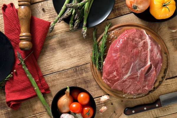 Fresh raw beef tenderloin with vegetables on wooden table — Stock Photo, Image