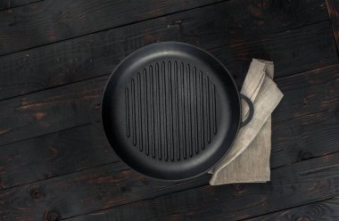 Koyu ahşap zemin üzerine peçete ile Vintage boş ızgara tava