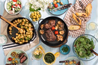 Yemek masası ile ızgara biftek, sebze, patates, salata, sn