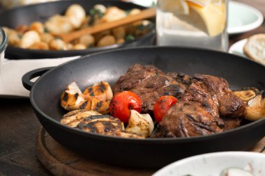 Ahşap masa üzerinde ızgara tava içinde sığır eti biftek ızgara