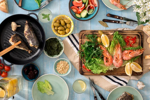 Mesa de cena familiar con camarones, pescado a la parrilla, ensalada, aperitivos, le — Foto de Stock