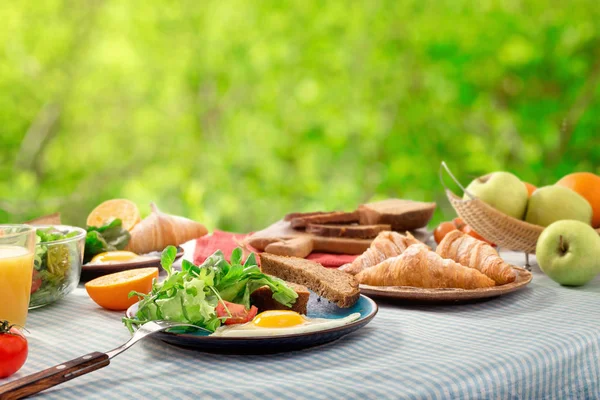 Завтрак с яичницей, круассанами, фруктами, салатом и джу — стоковое фото