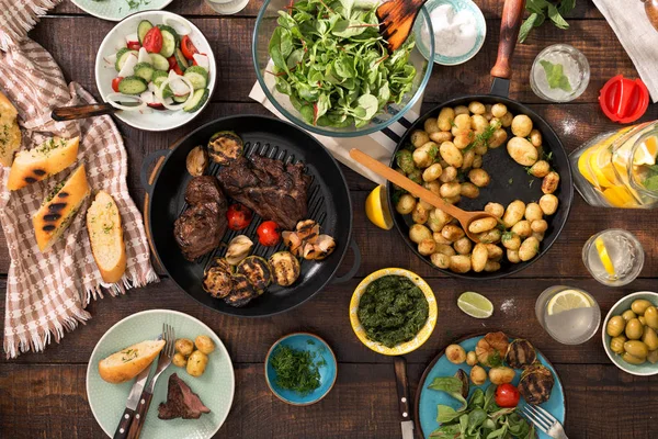 Mesa de cena con filete a la parrilla, verduras, patatas, ensalada, sn — Foto de Stock