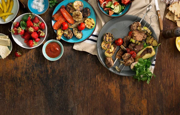 Grilled meat, grilled vegetables, salad, appetizers and strawber — Stock Photo, Image