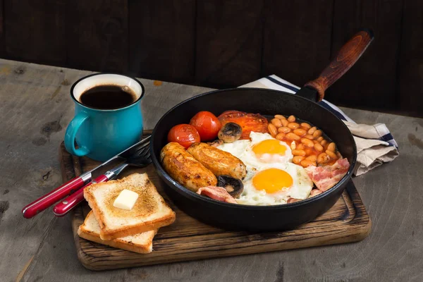 Pequeno-almoço inglês com salsichas, bacon, ovos fritos, feijão, torrada — Fotografia de Stock