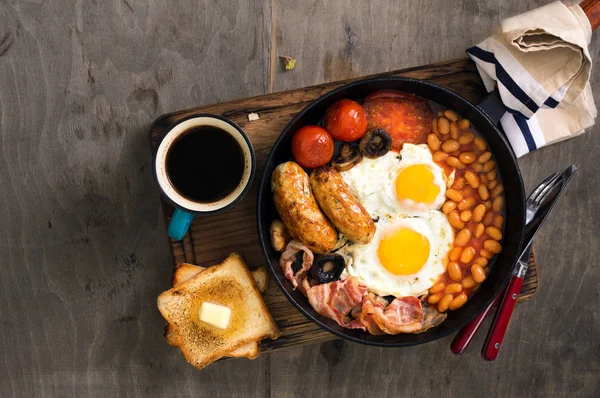 English breakfast with sausages, bacon, fried eggs, beans, toast — Stock Photo, Image