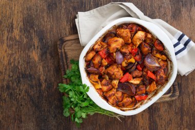 Rustik ahşap masa üzerinde sebzeli fırında tavuk göğsü