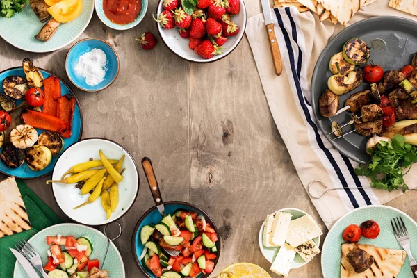 Shish kebab, grilled vegetables, salad, snacks and strawberries — Stock Photo, Image