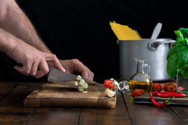 Adam ahşap bir masa üzerinde bir İtalyan makarna hazırlama