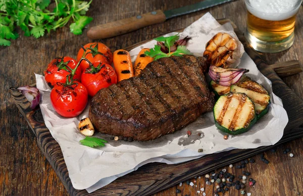 Hovězí grilovaný steak s grilovanou zeleninou a ležák pivo — Stock fotografie