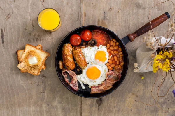 English breakfast on wooden light table with bouquet of wildflow — Stock Photo, Image