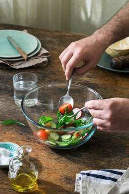 Adam akşam yemeği rustik ahşap masa salataya hazırlanıyor