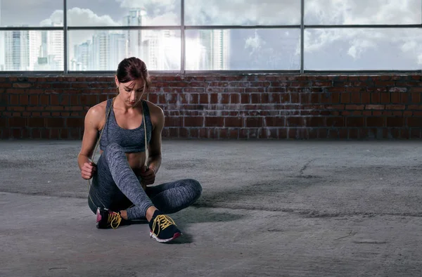 Woman athlete resting after training with rope sitting on floor — Stock Photo, Image