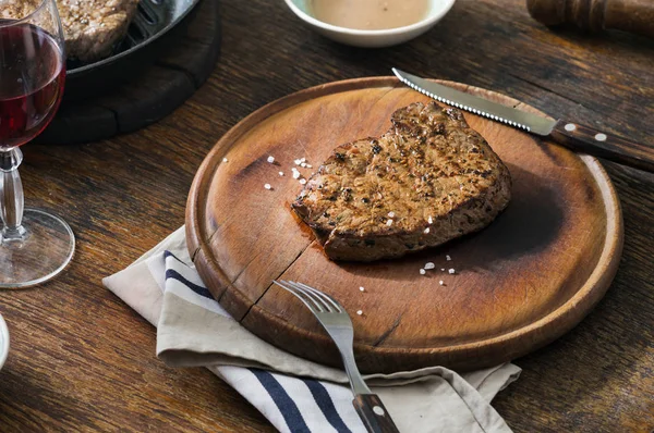 Carne de bovino bife grelhado raro com copo de vinho tinto — Fotografia de Stock