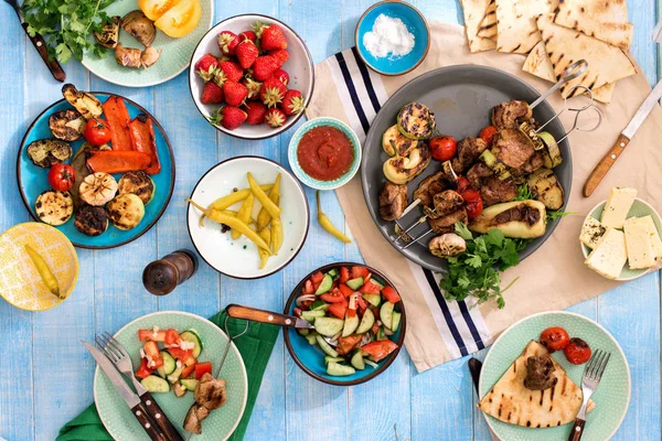 Eettafel met shish kebab gegrilde groenten, salade, snacks — Stockfoto
