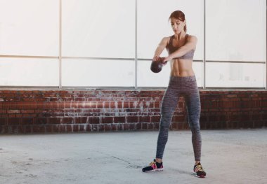 Genç kadın atlet spor egzersizleri dumbbells ile yapıyor