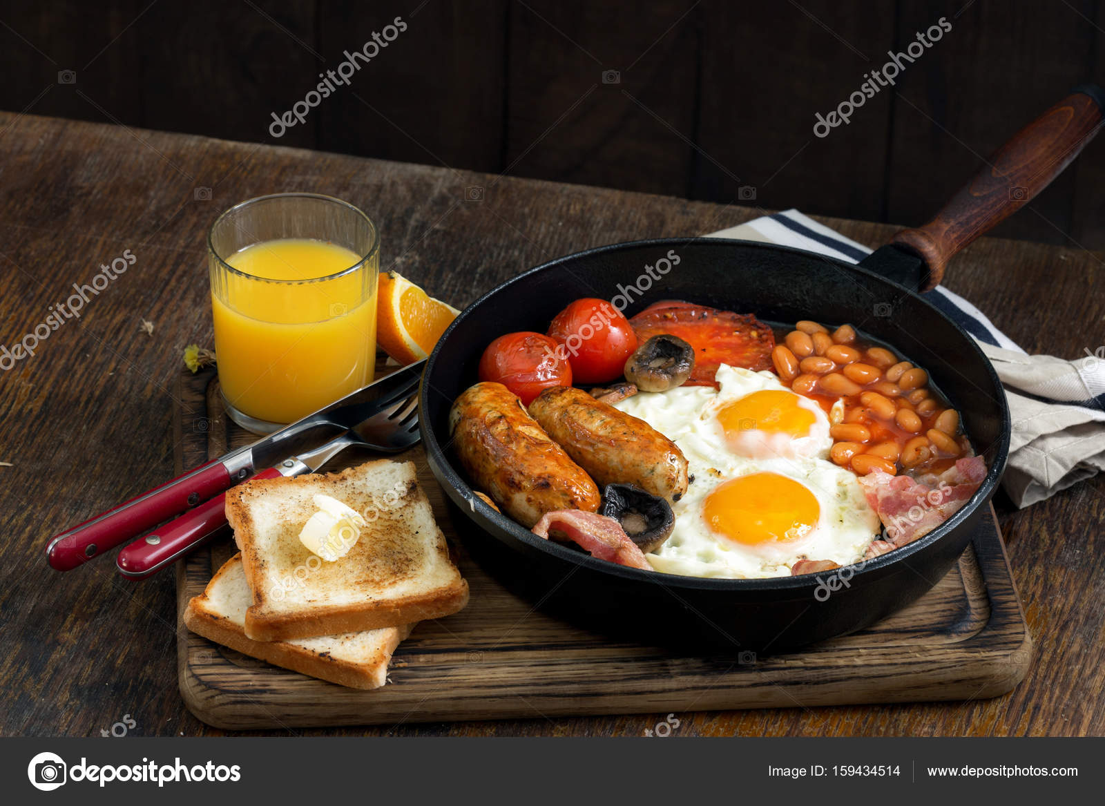 Desayuno inglés completo en tabla de madera con jugo de