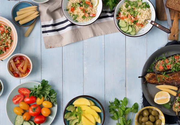 Rám z různých vegetariánských jídel na modrý venkovský dřevěný stůl — Stock fotografie