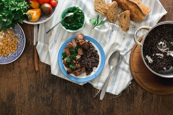 Placa con filete a la parrilla y quinua negra sobre mesa de madera — Foto de Stock