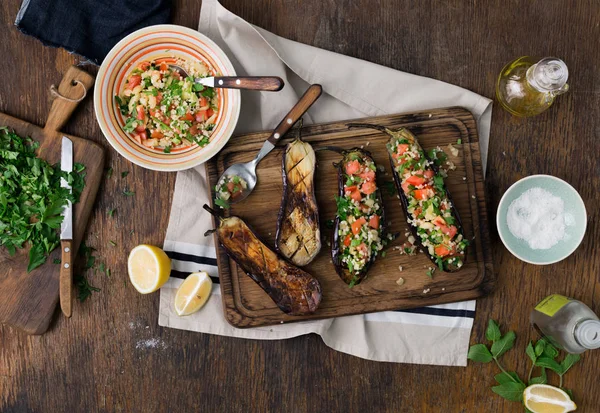 Berenjena relleno gachas bulgur y verduras en mesa de madera —  Fotos de Stock