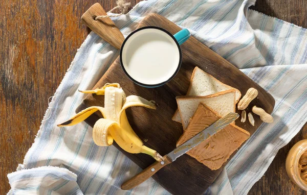 Desayuno saludable. Sandwich con mantequilla de maní, plátano y leche — Foto de Stock