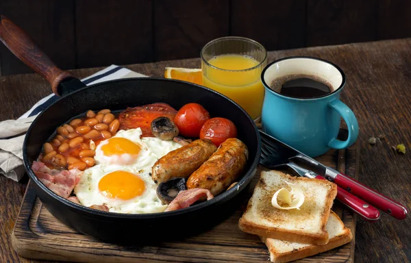 Café da manhã inglês em mesa de madeira com café e suco de laranja — Fotografia de Stock