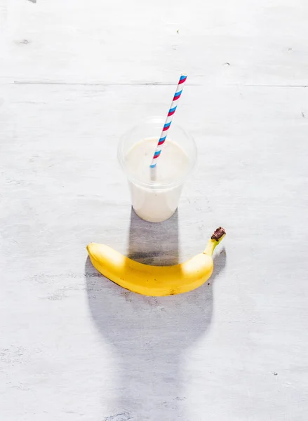 白のプラスチックのカップでバナナのミルクセーキ — ストック写真