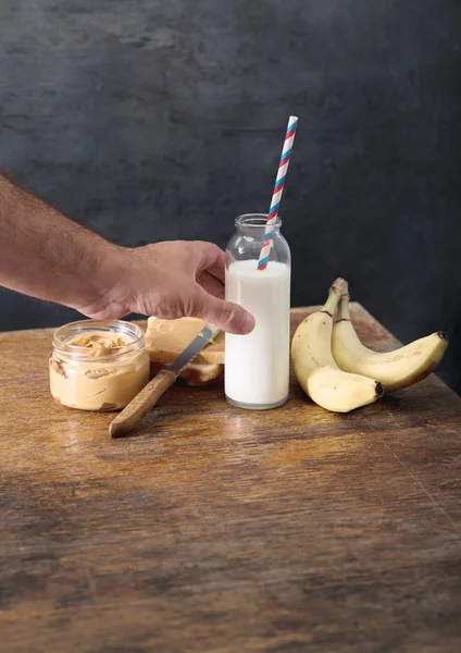 Бутылка молока с арахисовой пастой, тостами и бананами — стоковое фото