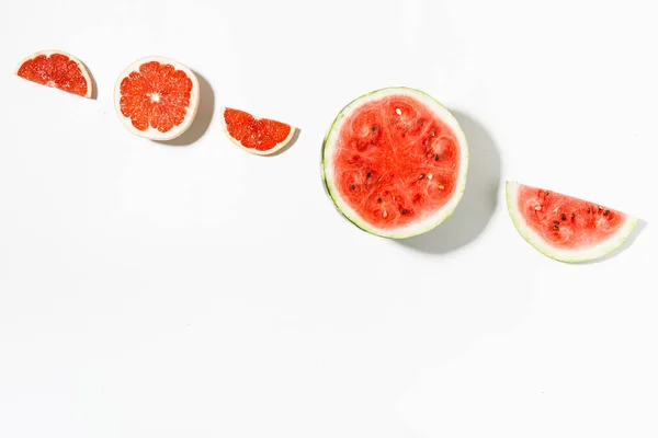 Segmenten van watermeloen en grapefruit op witte achtergrond. Platte la — Stockfoto