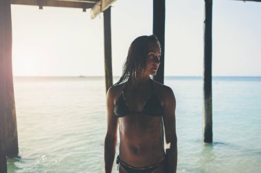 Bikinili güzel kadın okyanus kıyısında yürüyor