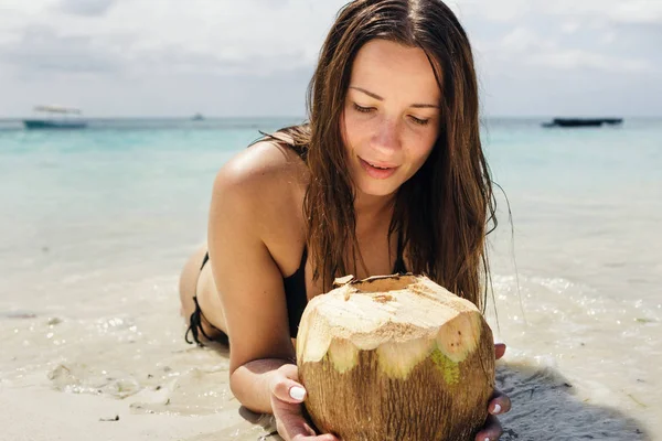 Красивая женщина ест свежий кокос — стоковое фото