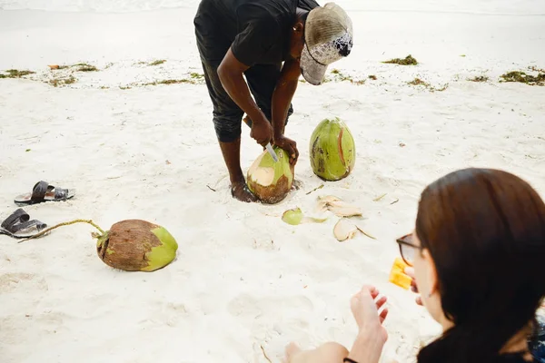 Африканский мужчина чистит кокос — стоковое фото