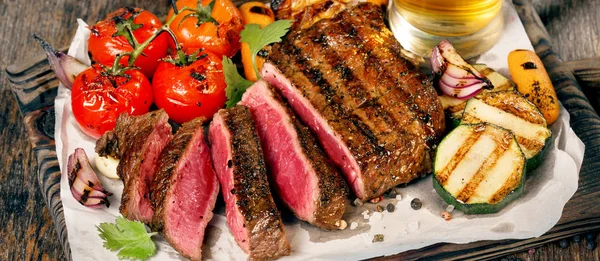 Krájené vzácné grilovaný steak s grilovanou zeleninou a ležák pivo — Stock fotografie