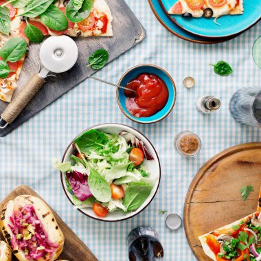 İtalyan pizza, sosis ızgara, salata, kırmızı şarap ve light bira, üstten görünüm. Çeşitli lezzetli yiyecekler, üstten görünüm, rustik tarzı ile yemek masası