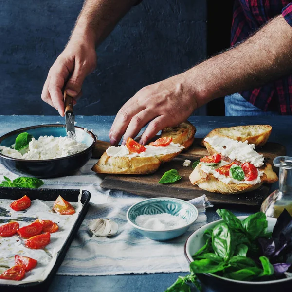 Man Voorbereiden Italiaanse Bruschetta Met Gebakken Tomaten Basilicum Kaas Italiaans — Stockfoto