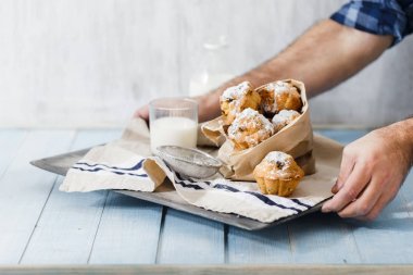 Ev yapımı kekler ve süt, ahşap tepsi holding erkek eller yakın çekim