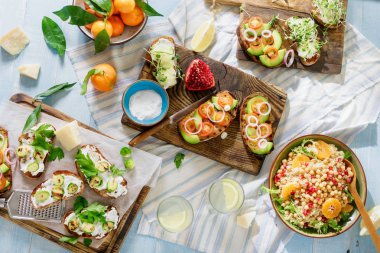 Vejetaryen yemekler ev yapımı limonata ışık mavi ahşap tablo. Bruschetta domates, salatalık, Brüksel lahanası ve nohut ve quinoa salata ile ana sayfa görünümü.