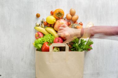 Üstten Görünüm kağıt torba farklı sağlık gıda düz beyaz ahşap zemin üzerinde yatıyordu 