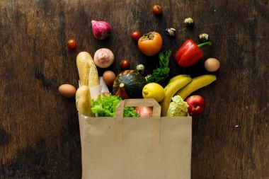 Üstten Görünüm kağıt torba koyu ahşap arka plan üzerinde farklı sağlık gıda