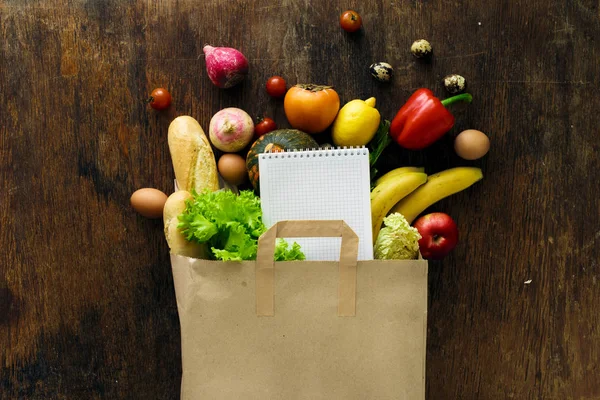 Saco Papel Diferentes Alimentos Saudáveis Notebook Sobre Fundo Madeira Vista — Fotografia de Stock