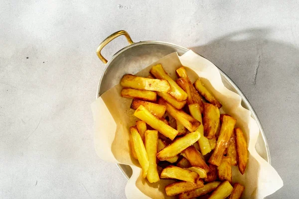 Stekt potatis i stekpanna på vit bakgrund, ovanifrån — Stockfoto