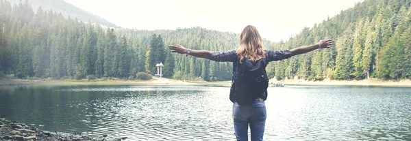 Mladá dívka stojí poblíž horské jezero — Stock fotografie