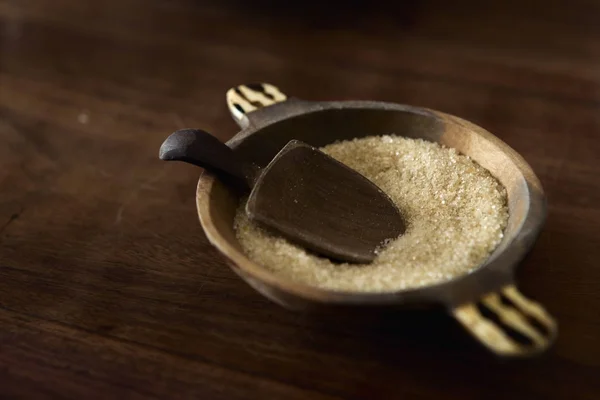 Zucchero di canna con cucchiaio di legno in zuccheriera tavolo di legno — Foto Stock