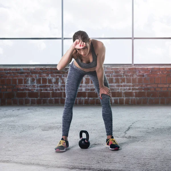 Woman athlete resting after training with dumbbells — Stock Photo, Image