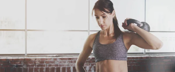 Mujer joven atleta en ropa deportiva haciendo ejercicios con pesas —  Fotos de Stock