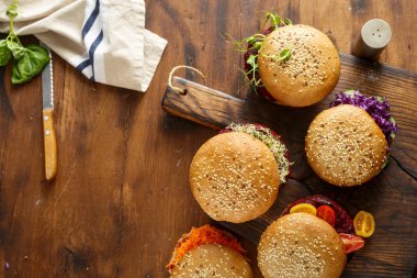 Sınır, üstten görünüm ahşap bir zemin üzerine vejetaryen Burger farklı ayarla. Sağlıklı gıda arka plan