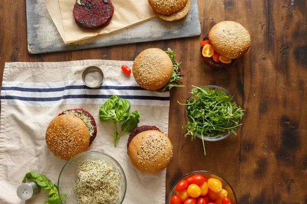 Set of vegetarian burgers on a wooden background, top view. Healthy food background