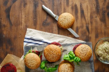 Pancar pirzola ve kuru erik, roka ve koyu ahşap masa, yonca vejetaryen Burger görünümü top